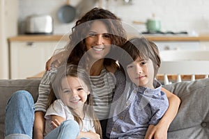 Portrait of young mom rest on couch with kids