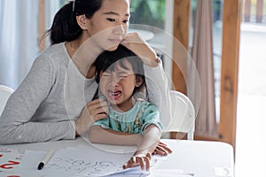 Mother comfort her crying daugther at home photo