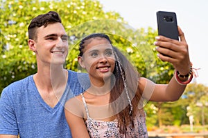 Portrait of young multi ethnic couple relaxing together at the park