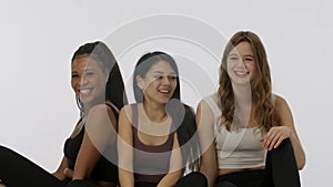 Portrait of young multiethnic models isolated on white studio background. Group of three positive multiracial girls