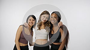 Portrait of young multiethnic models on white studio background close up. Group of three appealing multiracial girls