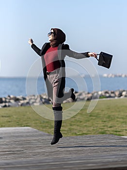 Portrait of young muslim woman jumping