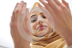 Portrait of young muslim woman making dua, praying to God