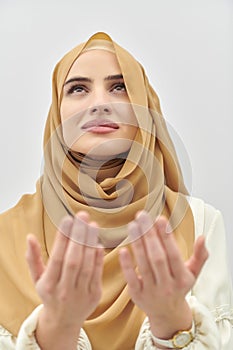 Portrait of young muslim woman making dua, praying to God