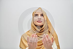 Portrait of young muslim woman making dua, praying to God