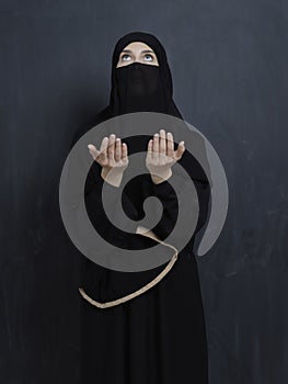 Portrait of young Muslim woman with niqab making dua