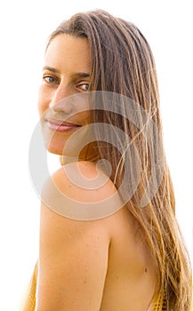 Portrait of a young natural beauty with long hair and shoulder facing the camera whose eyes look straight into the camera