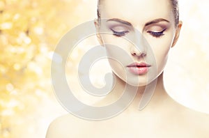 Portrait of young, natural and healthy woman over yellow autumn background. Healthcare, spa, makeup and face lifting