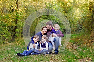 Portrait of young parents with three children. Mother, father, two kids brothers boys and little cute toddler sister