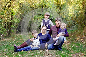 Portrait of young parents with three children. Mother, father, two kids brothers boys and little cute toddler sister