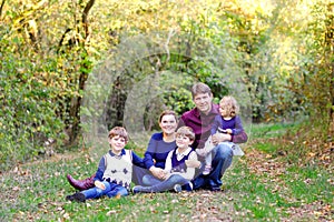 Portrait of young parents with three children. Mother, father, two kids brothers boys and little cute toddler sister