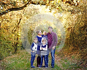 Portrait of young parents with three children. Mother, father, two kids brothers boys and little cute toddler sister