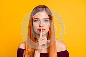 Portrait of young person finger touch lips show do not tell gesture isolated on yellow color background