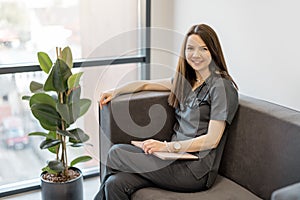 Portrait of a young physician on a couch at clinic