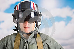 Portrait of young pilot wearing helmet with a sky