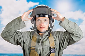 Portrait of young pilot wearing helmet with a sky