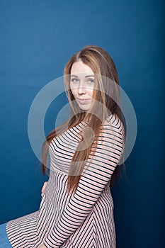 Portrait of  young plus size girl   in  dress on  blue background
