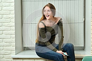 Portrait of young positive girl 20s years old with long blonde hair in jeans