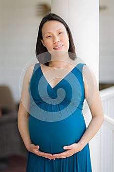 Portrait of Young Pregnant Chinese Woman on the Front Porch