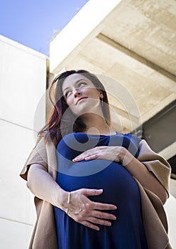 Portrait of young pregnant lady with bege coat