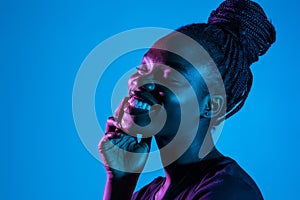 Portrait of young pretty african woman possing in neon light background. Skin care concept