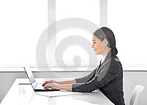 Portrait of young pretty business woman with laptop in the office