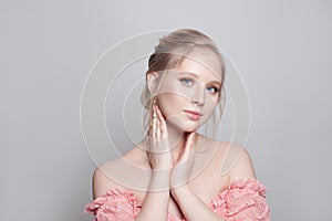 Portrait of young pretty gentle blonde woman with updo hairdo on white background