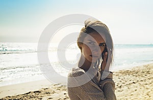 Portrait young pretty girl looking on summer beach, hipster in sand coastline on background seascape horizon blue sun ocean