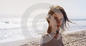 Portrait young pretty girl looking on summer beach, hipster in sand coastline on background seascape horizon blue sun ocean