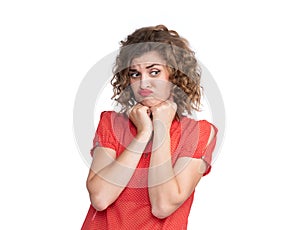 Portrait of a young pretty girl in a red dress with an emotional expression of resentment, isolated on white background. Pout her