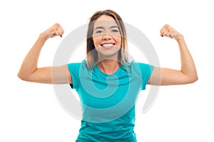 Portrait of young pretty girl wearing t-shirt flexing biceps gesture.
