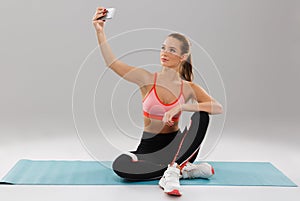 Portrait of a young pretty sportsgirl taking selfie