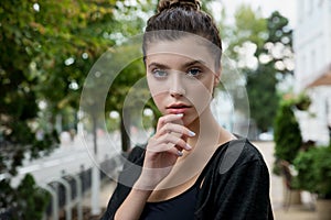 Portrait of young pretty student woman sitting at the city openspace