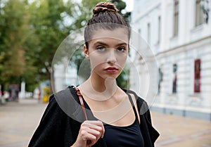 Portrait of young pretty student woman sitting at the city openspace