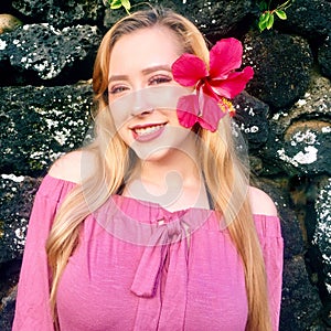 Portrait of Young pretty teenage girl smiling with Hawaiian flower in hair