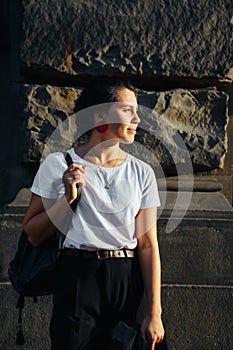 portrait of young pretty woman at city street sunset light