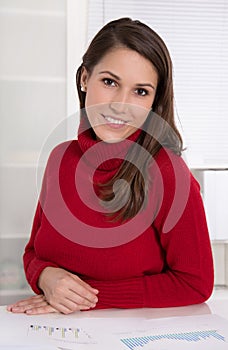 Portrait of a young pretty woman at desk - Trainee in an office photo