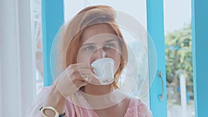 Portrait of young pretty woman drinking coffee in slow motion