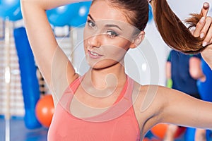 Portrait of a young pretty woman holding weights (dumbbell) and doing fitness indor. Crossfit hall. Gym shot