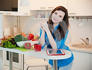 Portrait of young pretty woman in the kitchen.