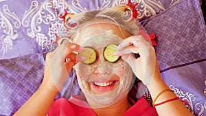 Portrait of young pretty woman in robe with cosmetic face mask