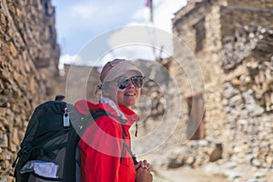 Portrait Young Pretty Woman Wearing Red Jacket Backpack Crossing Mountains Village.Mountain Trekking Rocks Path.Old Town