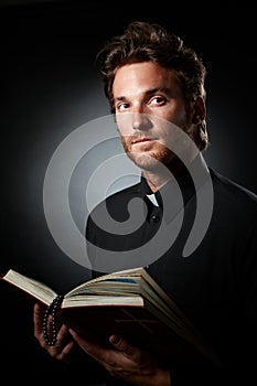 Portrait of young priest with Bible.