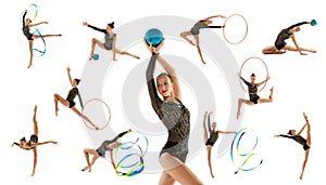 Portrait of young, professional female rhythmic gymnast training, performing isolated over white studio background