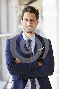 Portrait of young professional man in suit, arms crossed