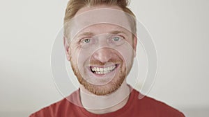 Portrait of young red haired man smiling at camera