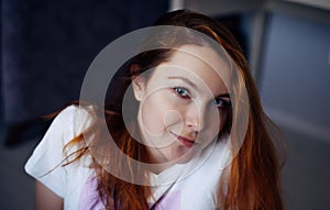 Portrait of young red-haired woman with perfect smooth skin. Face of beautiful girl, close-up. Female model in white t-shirt looks