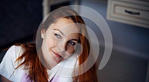 Portrait of young red-haired woman with perfect smooth skin. Face of beautiful girl, close-up. Female model in white t-shirt looks