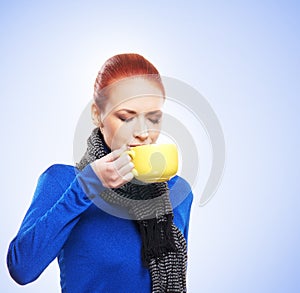 Portrait of a young redhead woman drinking tea