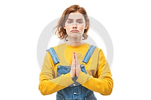 Portrait of young redhead woman folded her hands in prayer gesture isolated on white background. Peaceful, grateful, trusting